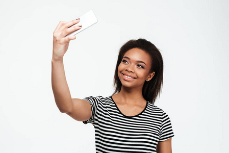 快乐年轻的非洲女人通过电话使自拍照