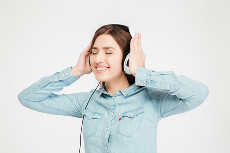 微笑的可爱可爱女士使用头戴式耳机，听音乐