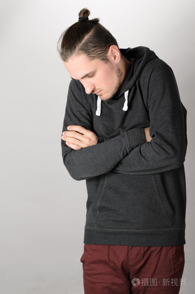 男子站在他的手臂交叉低头看着肩膀到一边从配置文件照片-正版商用