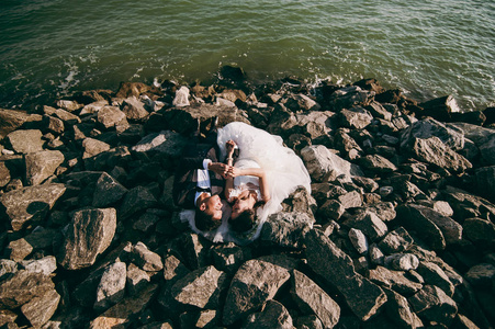 新婚夫妇在海滩上的岩石