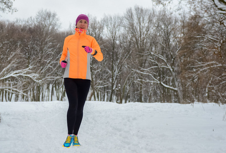 冬天在森林中运行 幸福的女人跑慢跑在雪 户外运动和健身概念