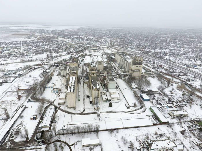 洒上雪谷物升降机。冬日里看来的旧苏联电梯。冬季从村庄的鸟瞰图。街道上覆盖着白雪