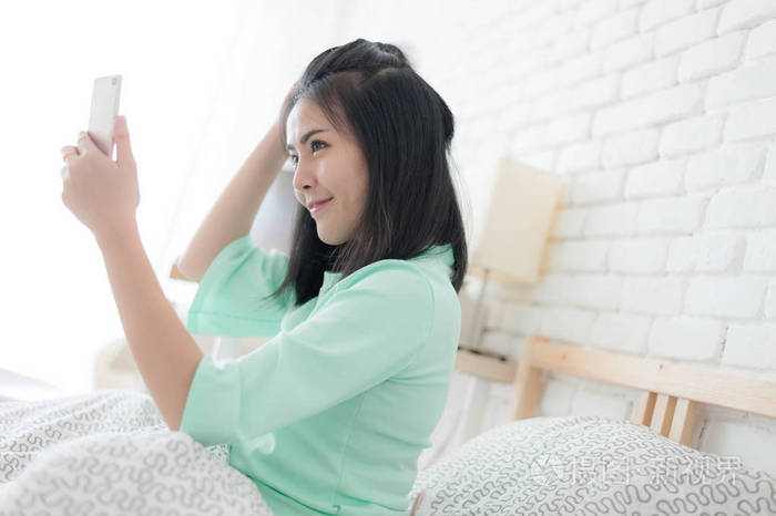 年轻的亚裔女子,在卧室里的自拍照合影