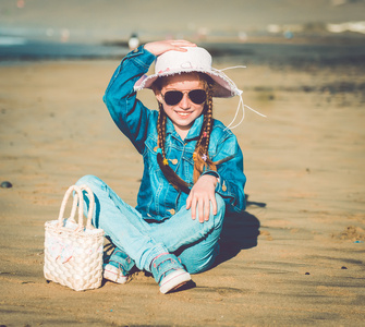 在海滩上的一顶帽子的小女孩