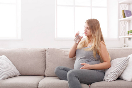 杯水，坐在沙发上的孕妇