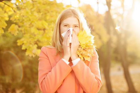 秋天背景下有感冒鼻炎的女孩。 秋季流感季节。 我是