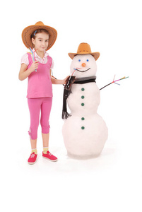 可爱的女孩，抱着可乐瓶附近雪人围巾和帽子