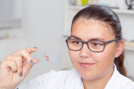 一个十几岁的女孩，在学校实验室在化学中，在实验室里做实验