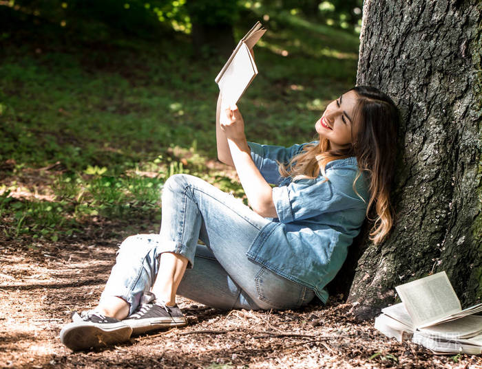 一棵树旁读书的女孩