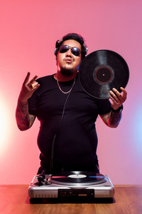 歌手说唱摆姿势坐在金属梯子的台阶上看着镜头的白种人胖子愤怒地看着