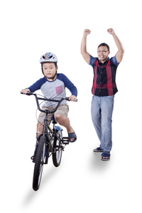 快乐的父亲和成功的男孩骑自行车