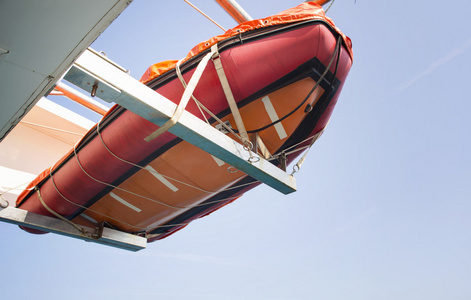 橙色的救生艇在海上挂在船上