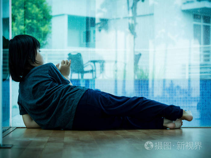 小男孩不高兴伤心胸前坐在空荡荡的房间孤独的树悲伤的孩子概念