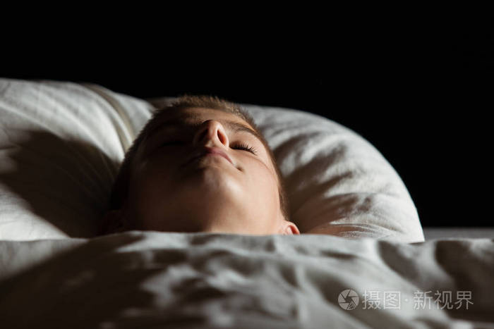 在睡在床上闭上眼睛的男孩