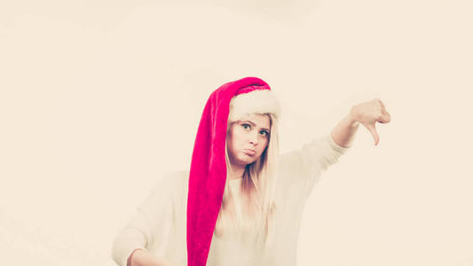 不快乐悲伤的女人，穿着圣诞老人帮手帽子