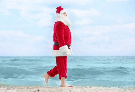 正宗圣诞老人走在海滩上