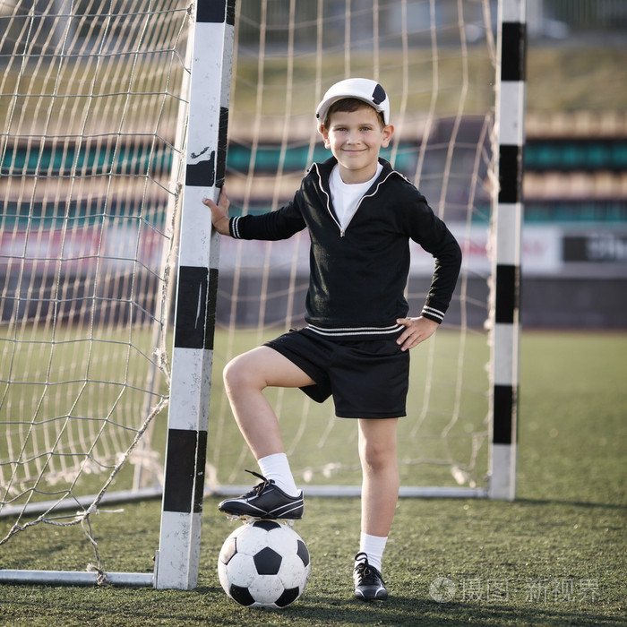 男孩在体育场踢足球