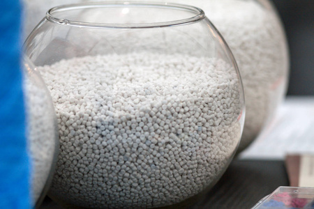 在对挤压厂制造塑料挤出机上的白色塑料颗粒照片