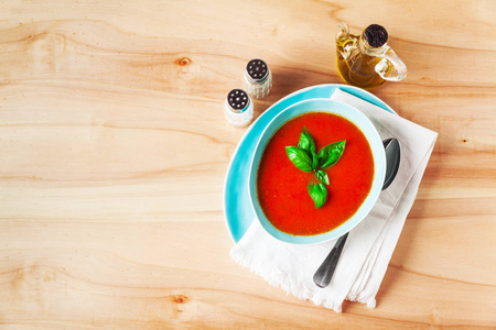 传统的奶油番茄汤配罗勒木制的桌子上的