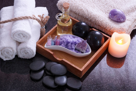 白毛巾由旁边的一套按摩从边石头 芳香油和紫色的盐，缠绕连接附近的石头为温泉按摩