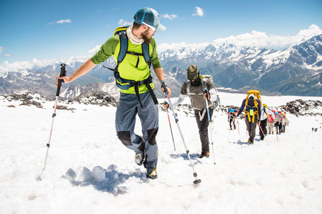 一群登山爬到白雪皑皑的山顶图片