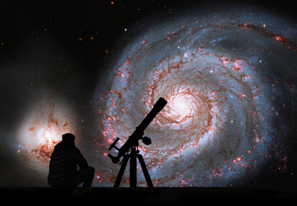 用望远镜仰望星空的人.旋涡星系 m51照片
