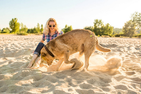 她的狗在沙滩上的年轻女子