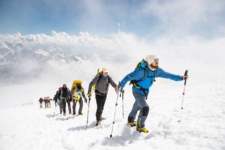 一群登山爬到白雪皑皑的山顶图片