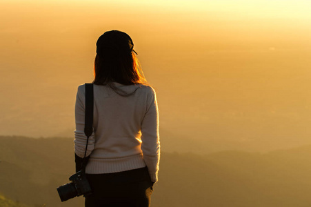 专业女摄影师看到山景在日出