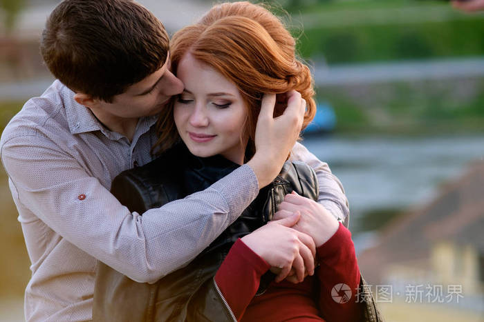 英俊的黑发男子浪漫m拥抱红发美女