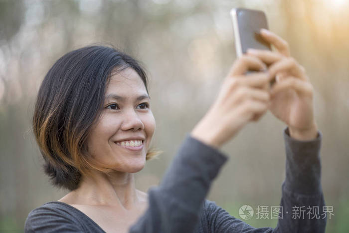 幸福的年轻女人，以智能手机之间的自拍照