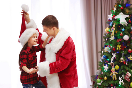 快乐的父亲和女儿在装饰圣诞房间有乐趣