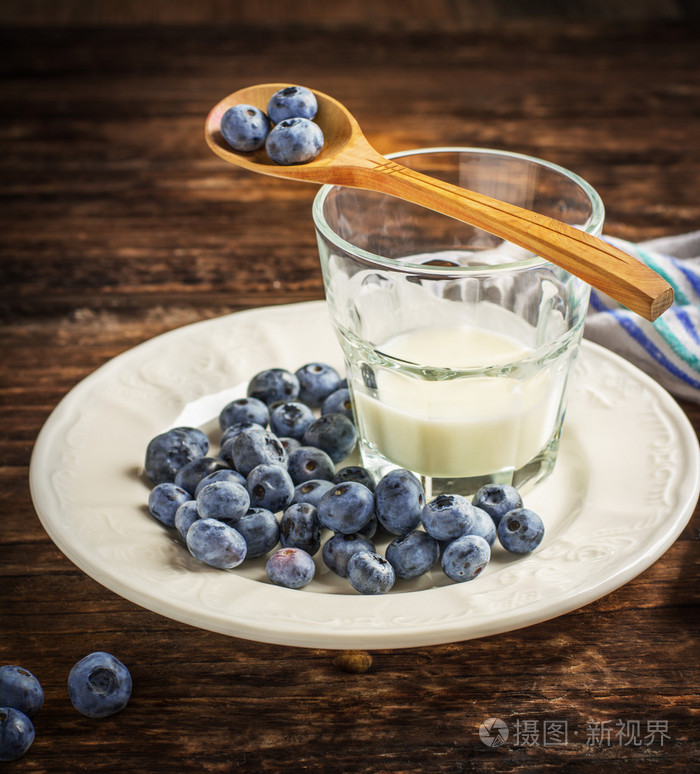 园艺与一杯新鲜的牛奶和蜂窝蓝莓