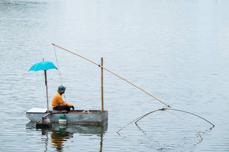 亚洲渔夫钓鱼在河的早晨