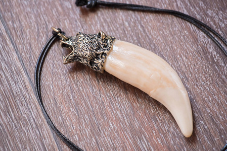 大熊牙, 骨吊坠雕刻从棕色背景上的鹿照片