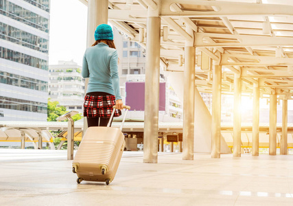 现代机场年轻女子拉行李箱在现代机场终端,旅游带走他的行李在运输中