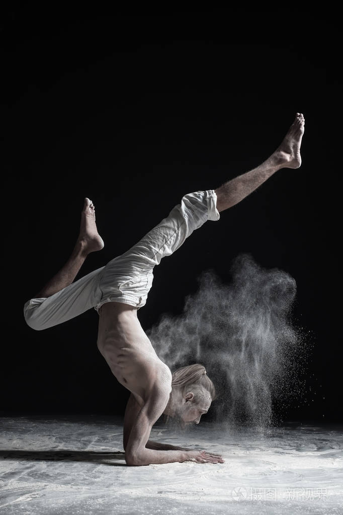 灵活的瑜伽男人做手平衡体式vrischikasana