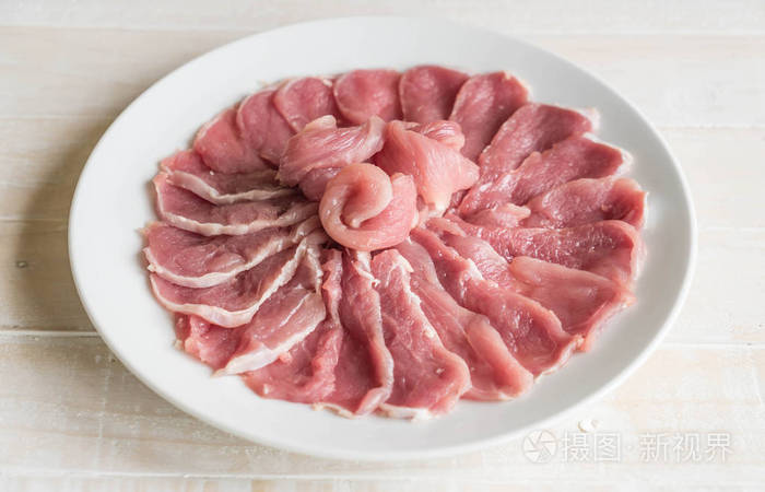 新鲜猪肉片在木头上