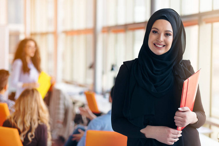 阿拉伯商界女强人带头巾拿着一个文件夹