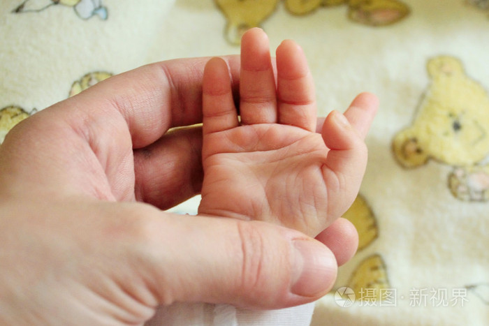 刚出生的婴儿手牵手,母亲照片