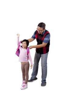 父亲帮助他的孩子穿背包