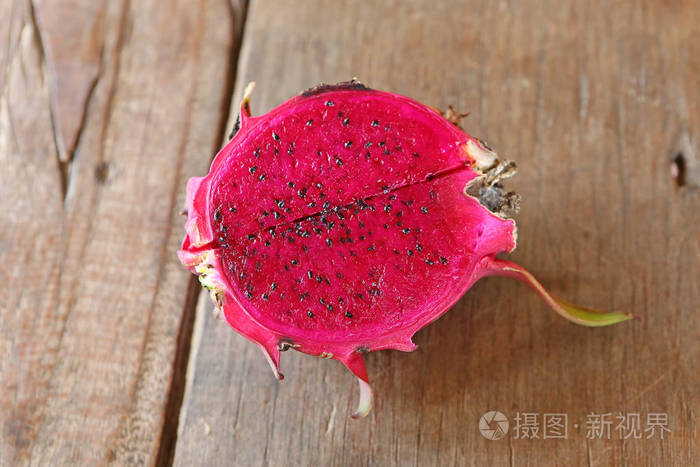 一半的成熟火龙果或火龙果在木桌上