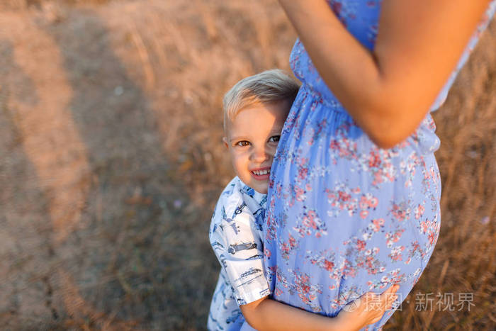 在模糊的自然背景上拥抱温柔的妈妈快乐的小儿子的特写镜头.