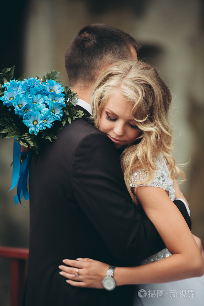 新婚快乐夫妇拥抱和微笑彼此在背景老城堡