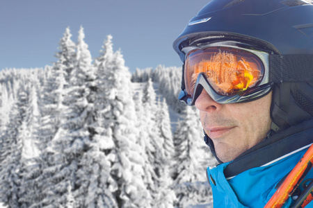 滑雪者穿着蓝色滑雪夹克 头盔和眼镜对雪森林全景