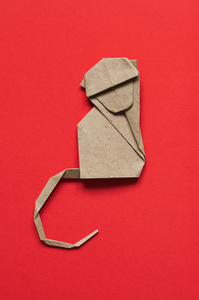 折叠纸折纸猴子在红色生态背景上. 纵向员额照片