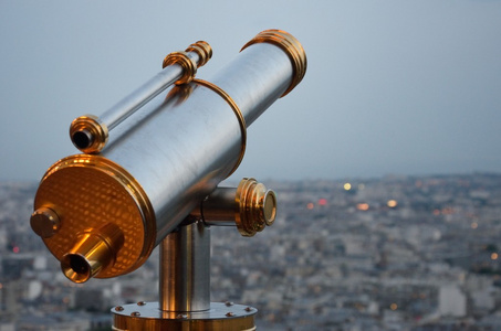 城市上空看着黄昏的老式望远镜