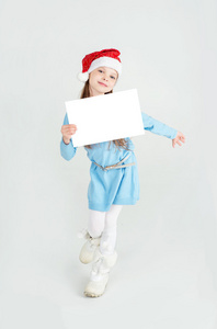 可爱的女孩在圣诞老人帽子与白色的空白纸张