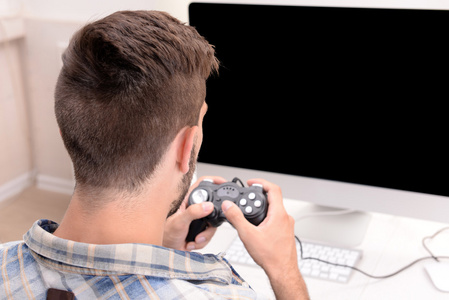 年轻人在家里玩电脑游戏