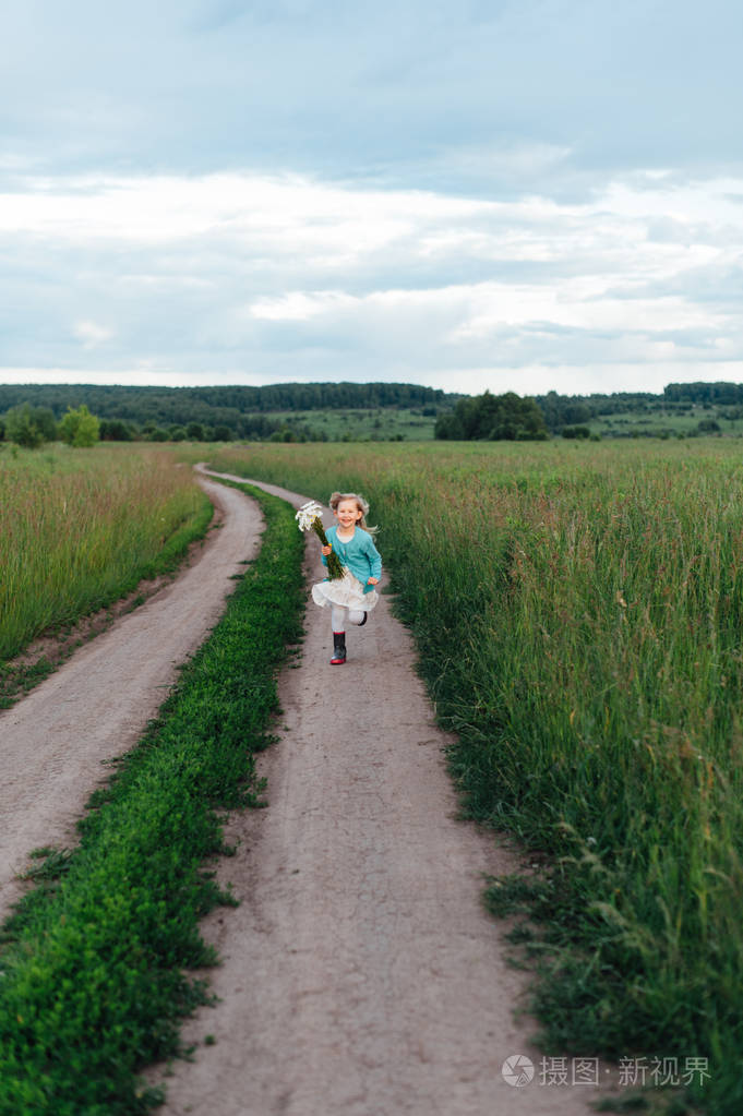 一个开朗的孩子捧着一束雏菊靴子的运行